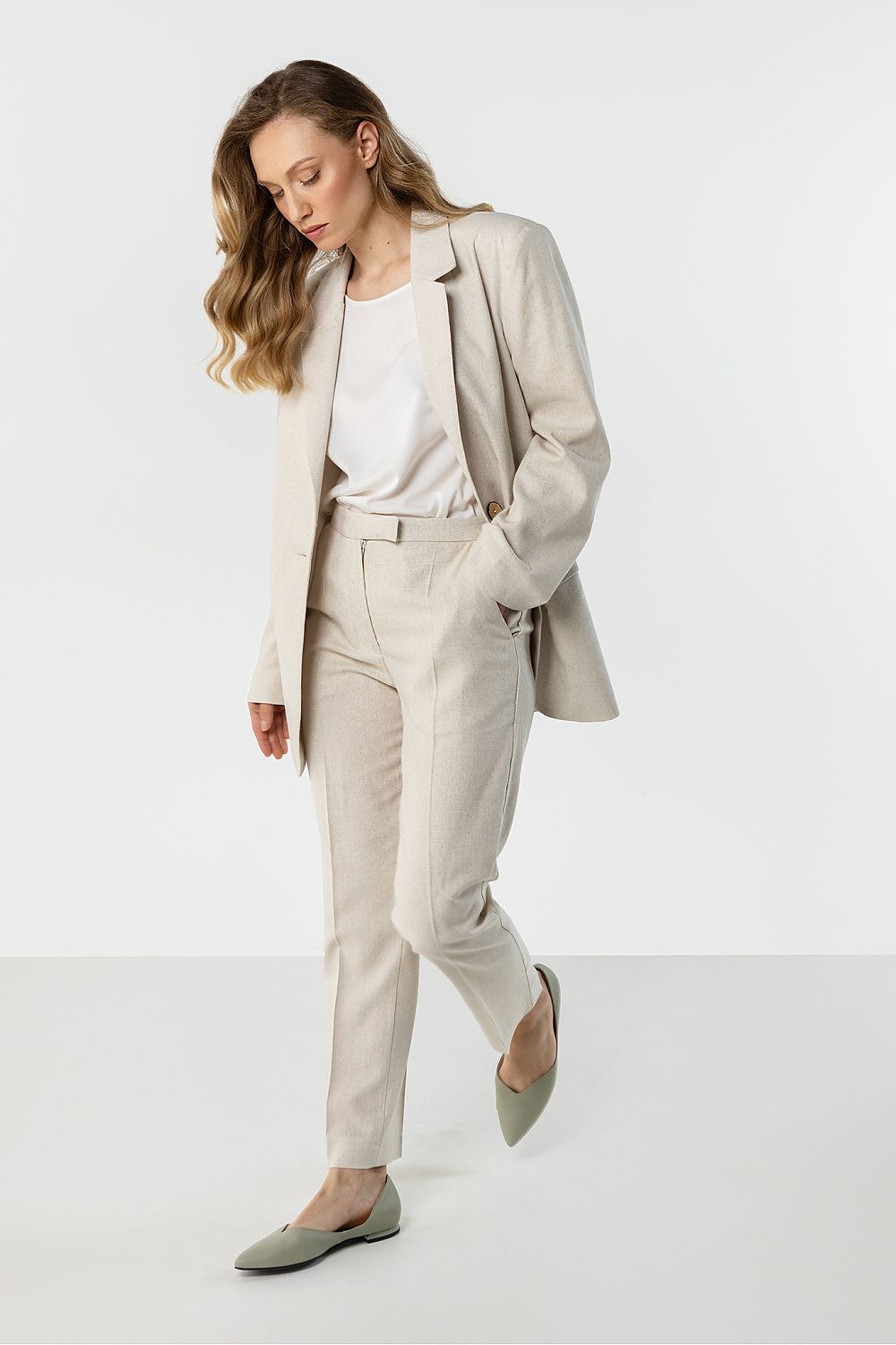 Women’s tailored trousers in light beige with front creases and slim ankle hem
