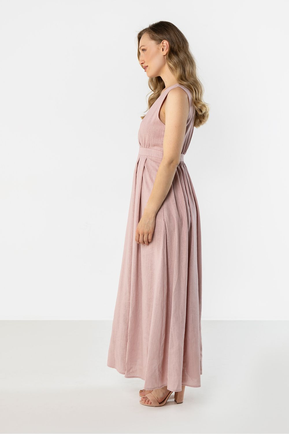 Pink sleeveless maxi daydress with V-neck and gathered waist, front panel folds, side view