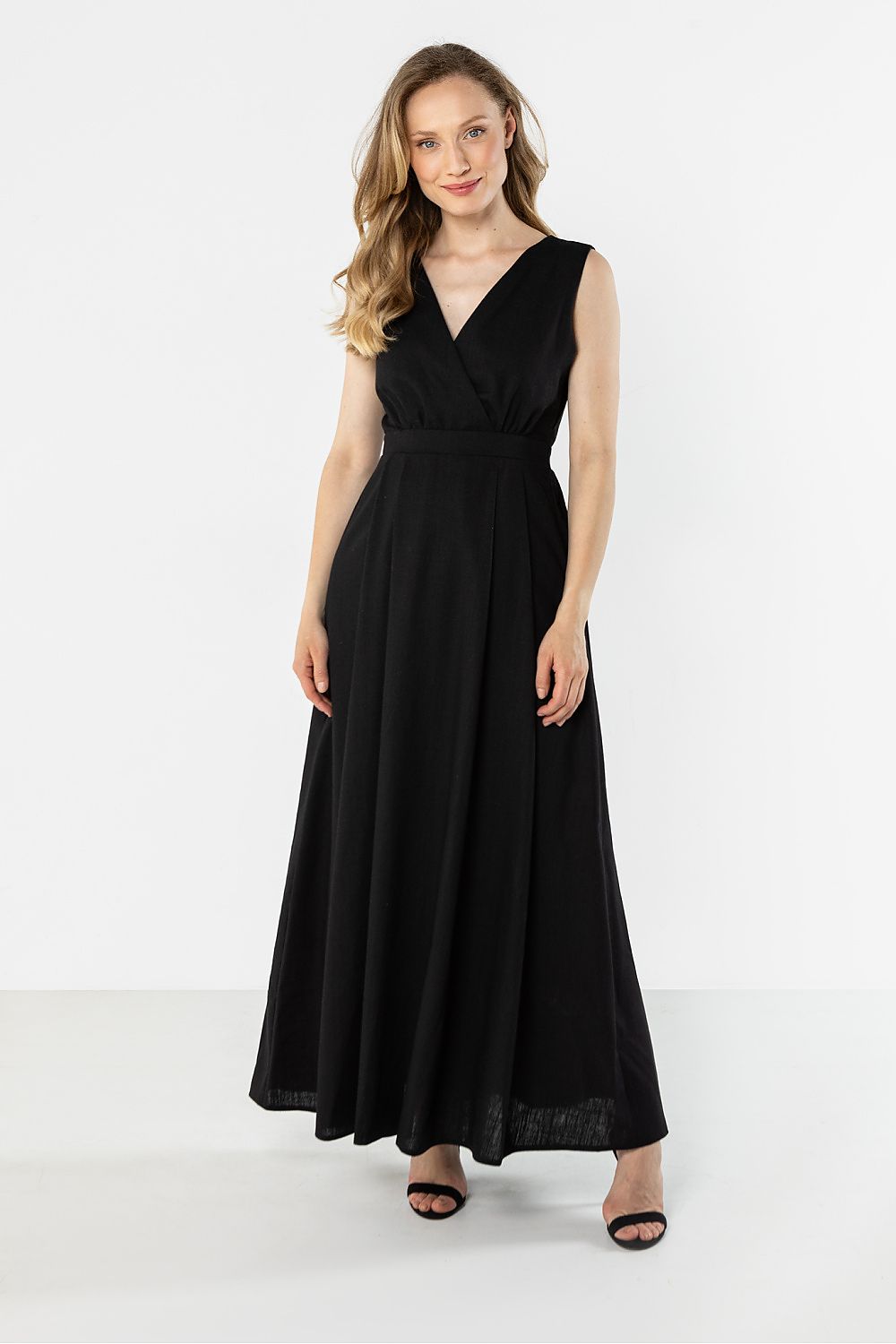 Black sleeveless maxi daydress with V-neck wrap styling and gathered waist seam, front view