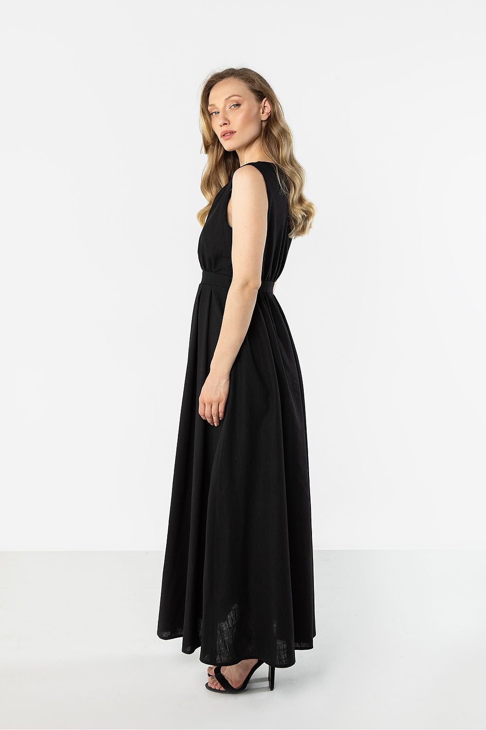 Black sleeveless V-neck daydress with gathered waist and full maxi skirt, side view