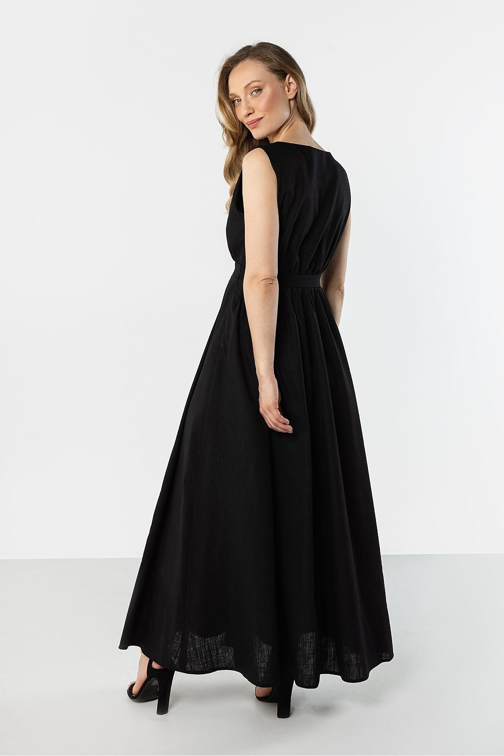 Black sleeveless maxi daydress with gathered waist and A-line skirt, back 3/4 view