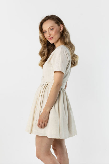 Cream short-sleeve daydress with ruched waist and flared skirt, side view