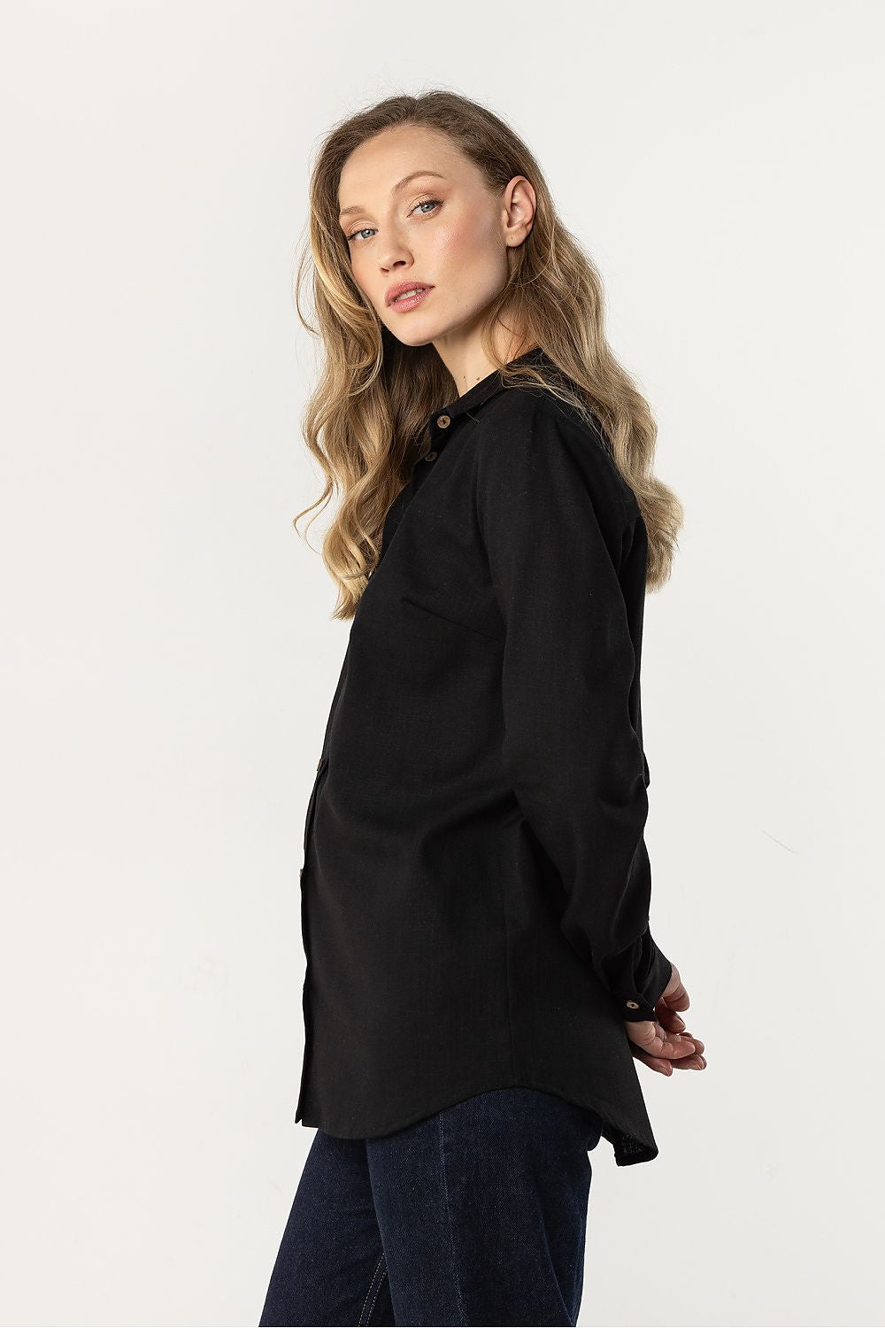 Awama long-sleeve shirt in black, side view with long sleeves and button placket