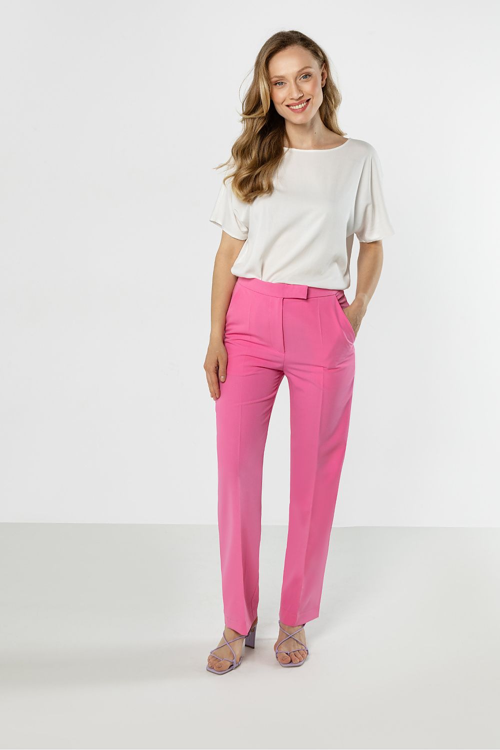 Pink trousers with belt loops, front pleats, and tapered ankle-length hem