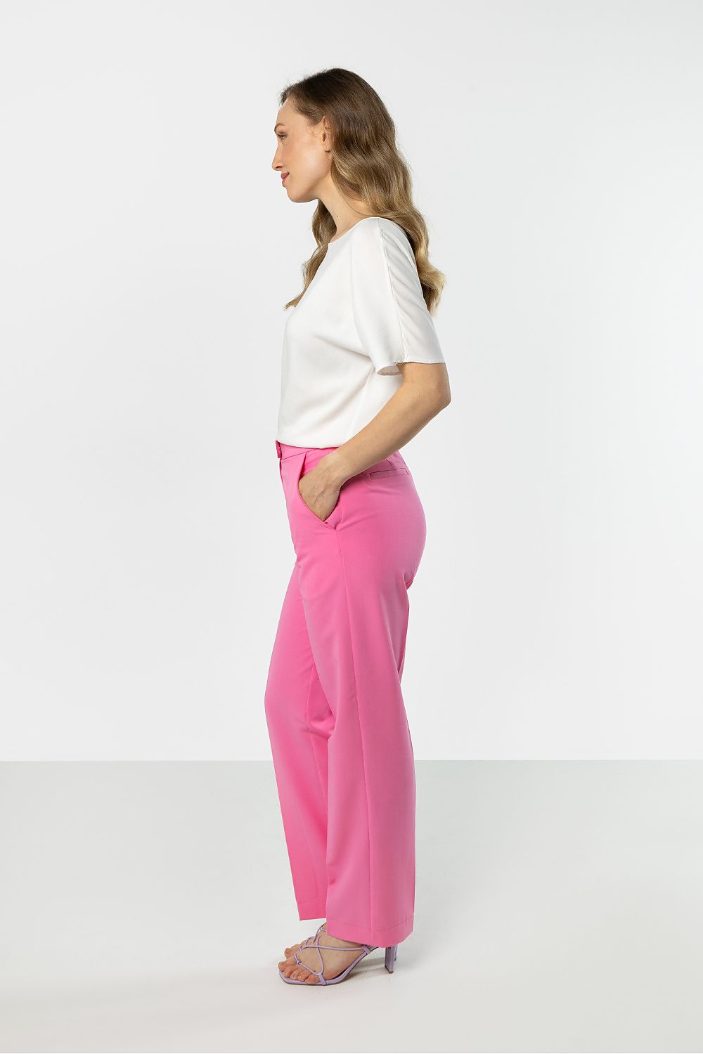Pink trousers, side view; belt loops and ankle-length tapered cut