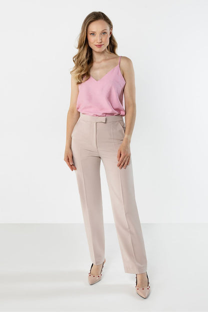 Beige trousers with belt loops, front pleats, and tapered ankle-length legs