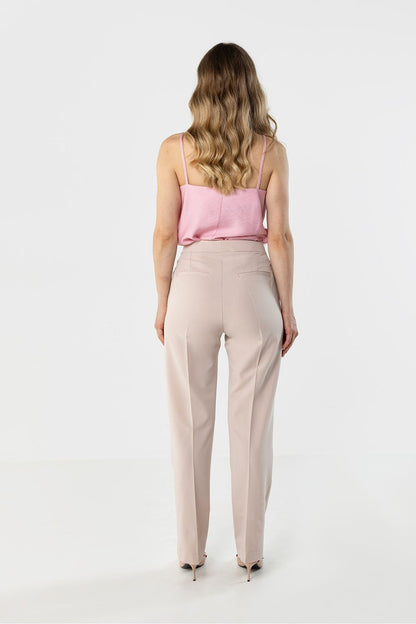 Beige trousers, back view; belt loops and tapered ankle-length silhouette