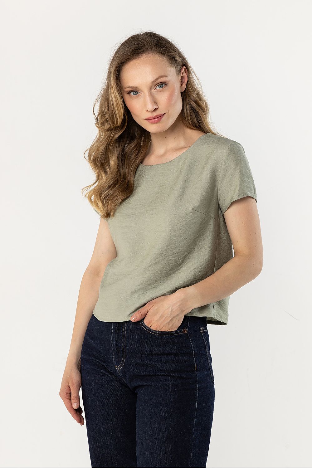 Green short-sleeve crewneck blouse, draped fit, worn with dark jeans