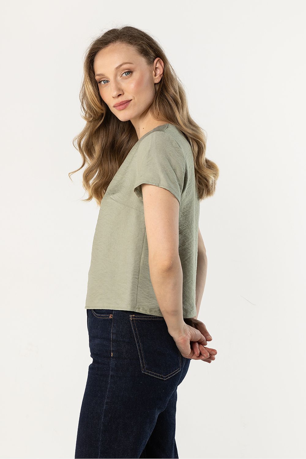 Green short-sleeve crewneck blouse, side view with relaxed drape