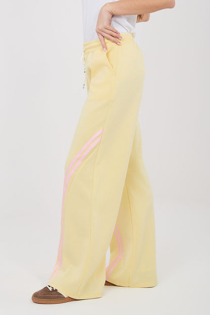 Tracksuit trousers, pale yellow wide-leg with pink side stripe and drawstring waist