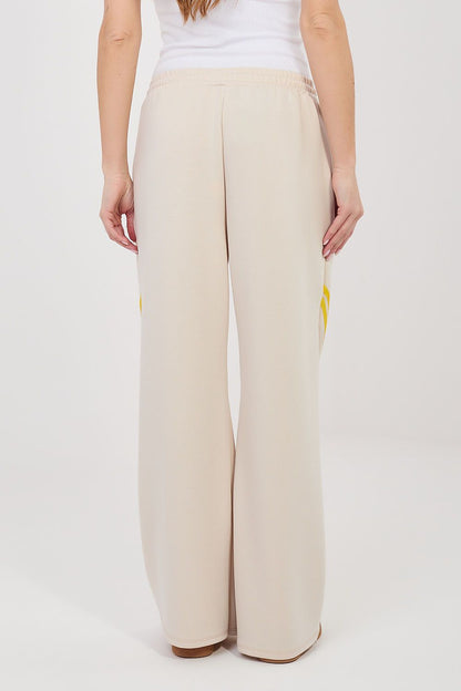 Tracksuit trousers, light beige back view with elastic waist and yellow side stripe detail