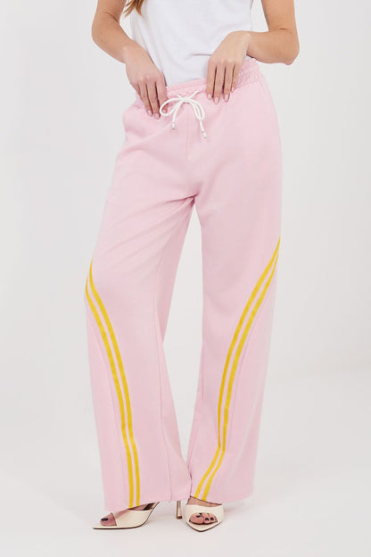 Pink tracksuit trousers with drawstring waist and yellow side stripe accents.
