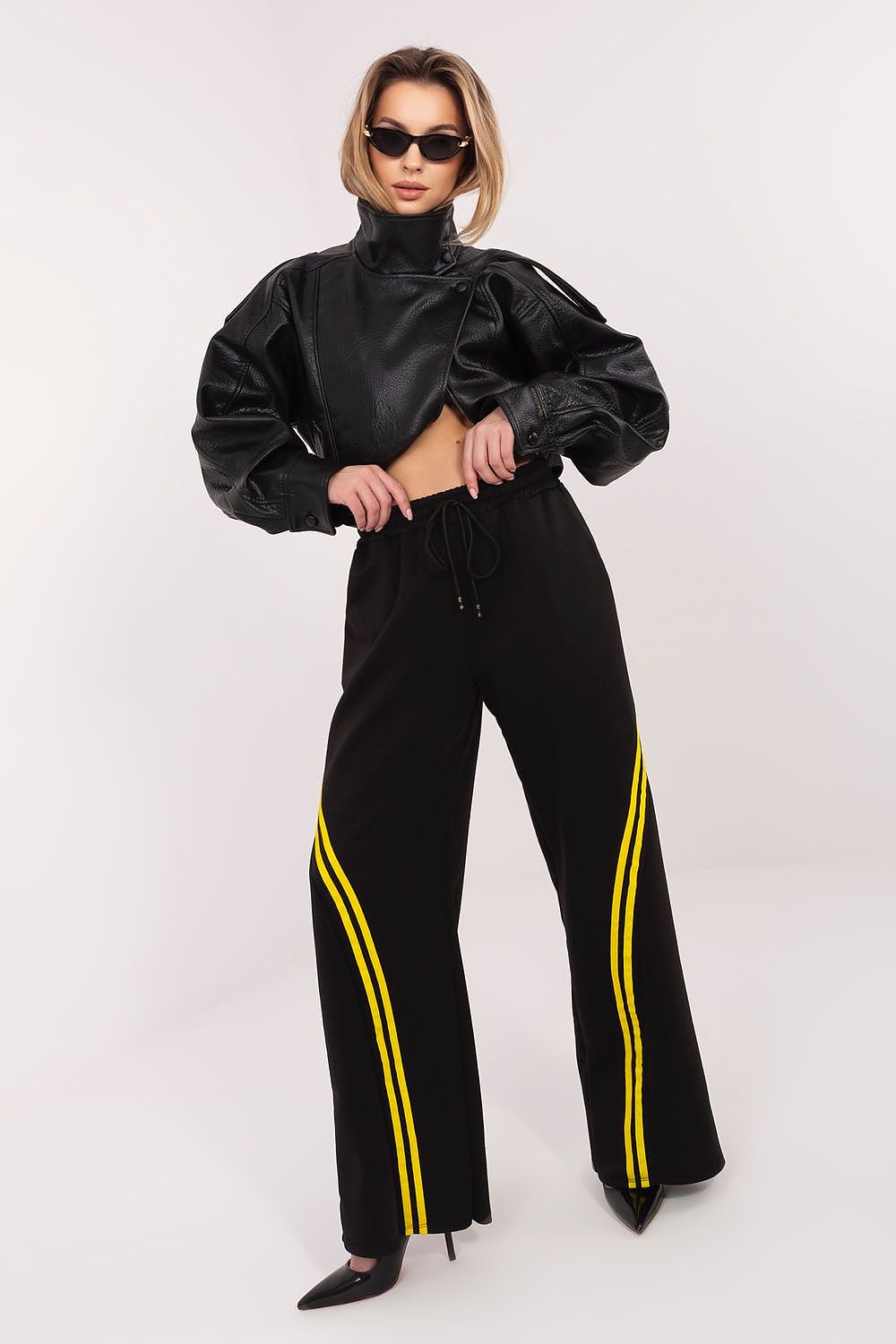 Black tracksuit trousers with drawstring waist and yellow side stripe detail.