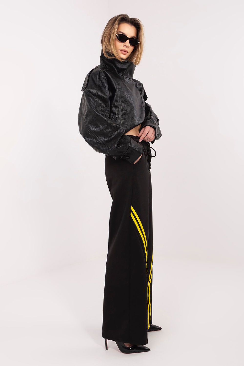 Black wide-leg tracksuit trousers with drawstring waist and yellow side stripe detail.
