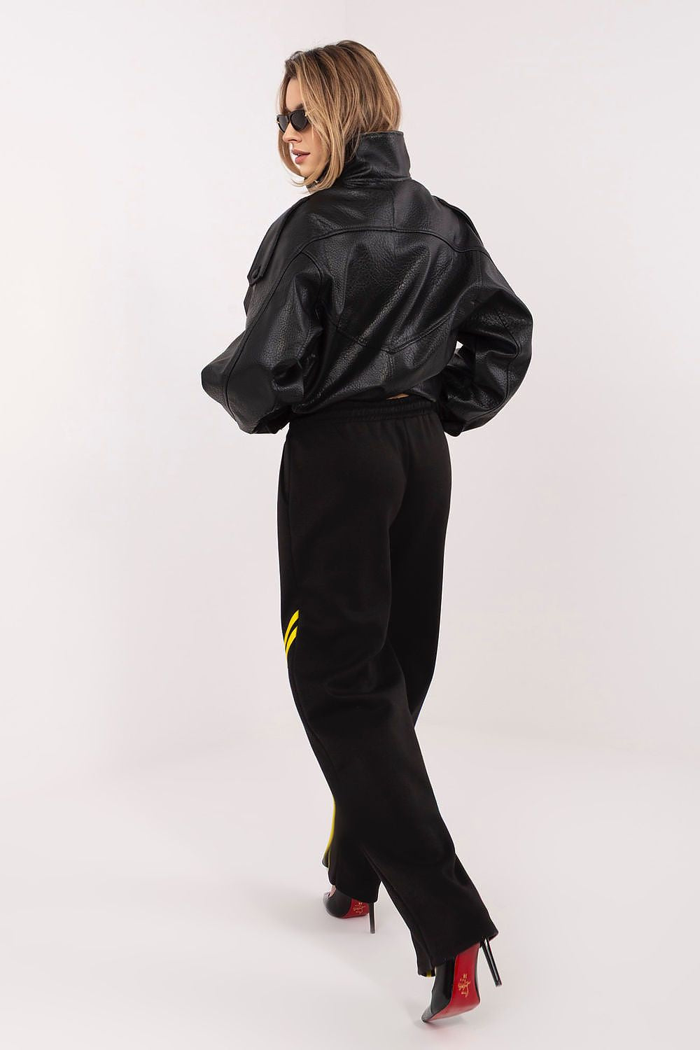 Black tracksuit trousers with drawstring waist and yellow side stripe on legs.
