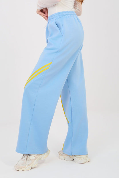 Light blue tracksuit trousers with drawstring waist and yellow side stripe accents.