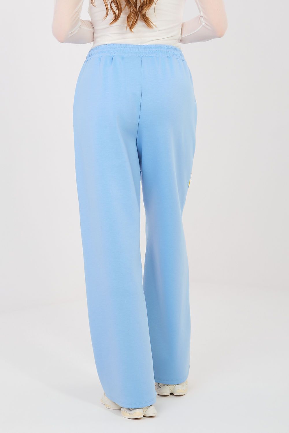 Light blue tracksuit trousers with elastic waist and relaxed wide-leg silhouette.