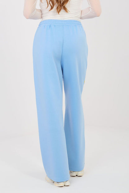 Light blue tracksuit trousers with elastic waist and relaxed wide-leg silhouette.