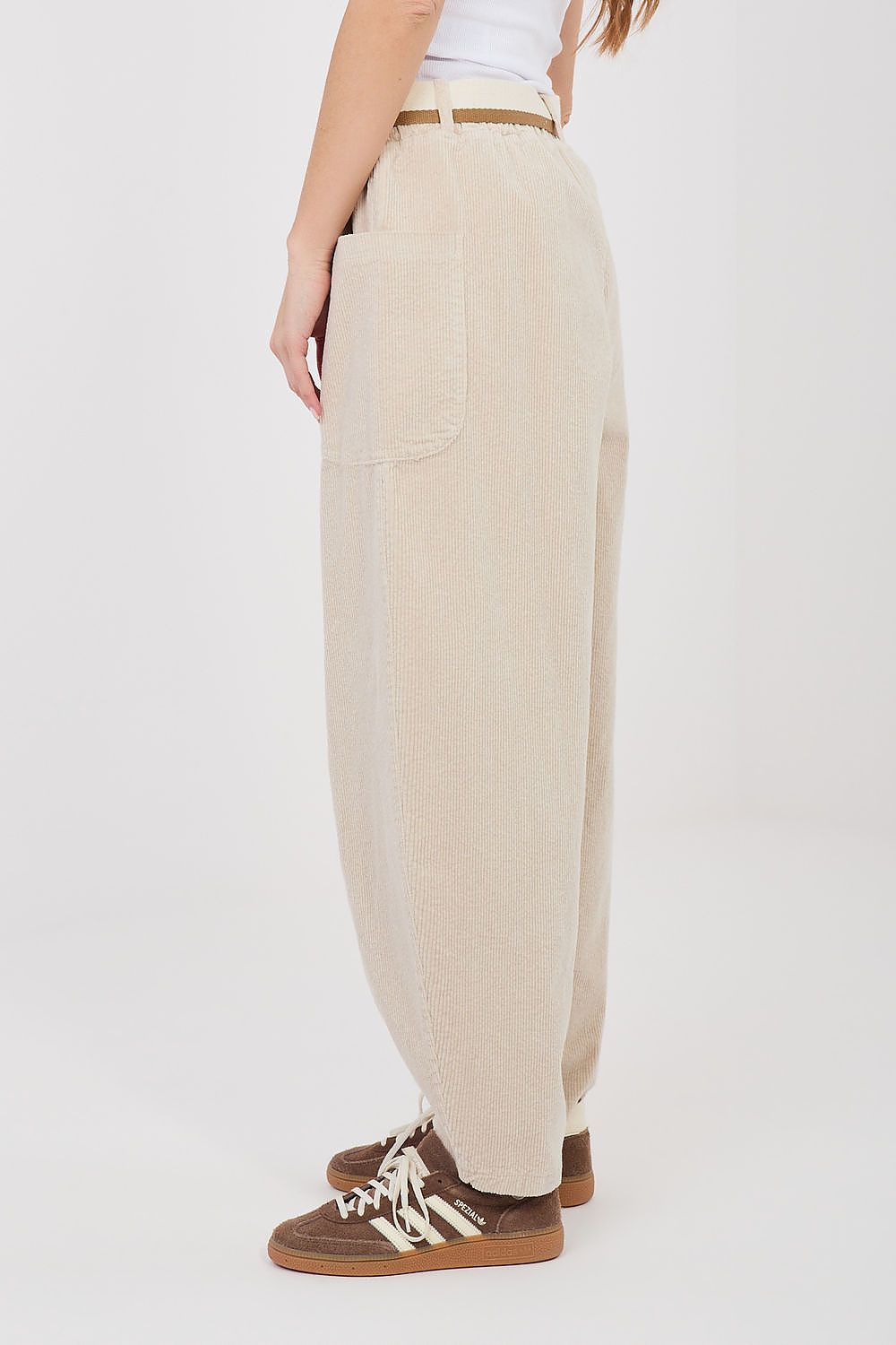 Beige corduroy trousers with large side pockets and belt loops, relaxed fit