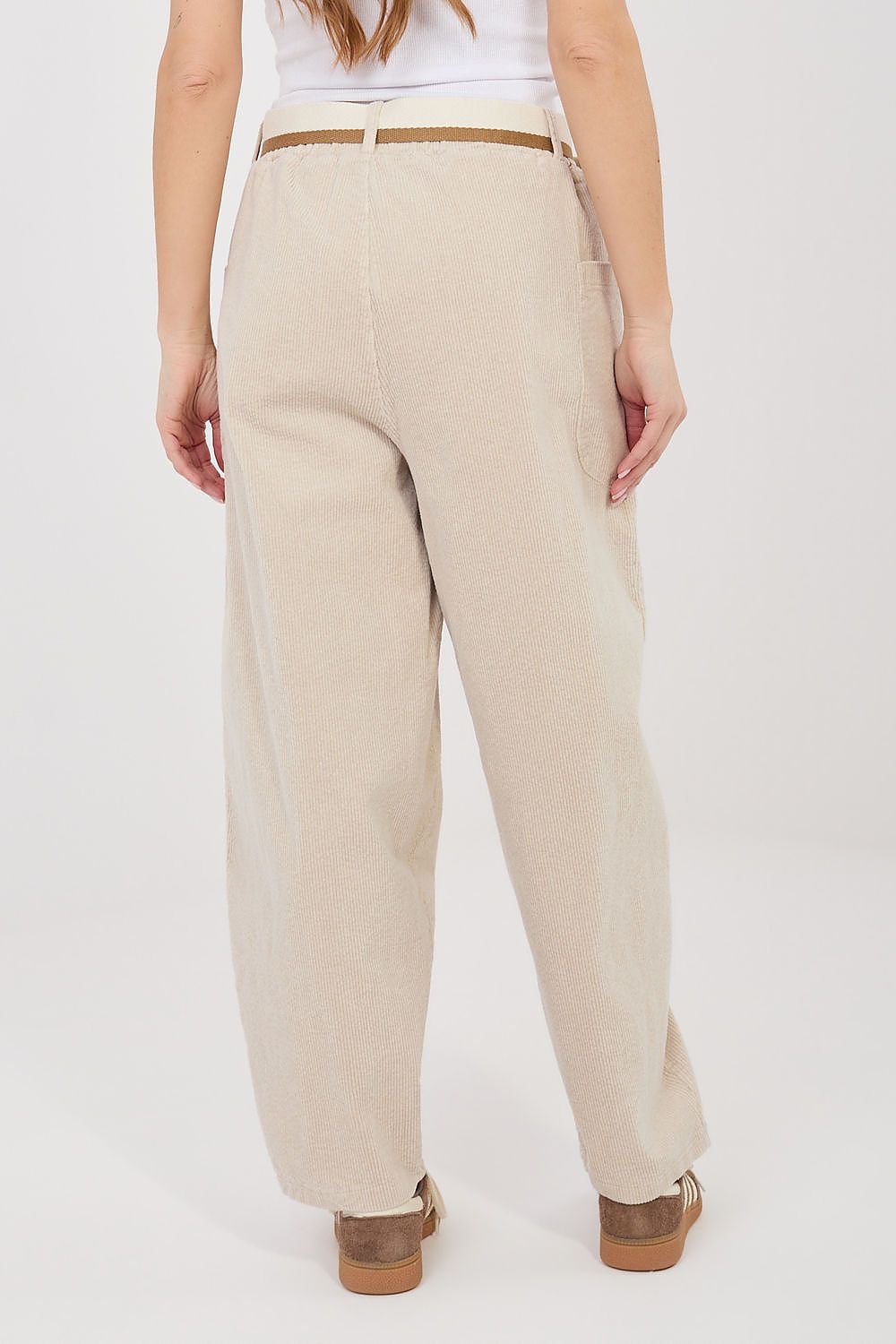 Beige corduroy trousers with high waist, side pockets, and relaxed tapered legs