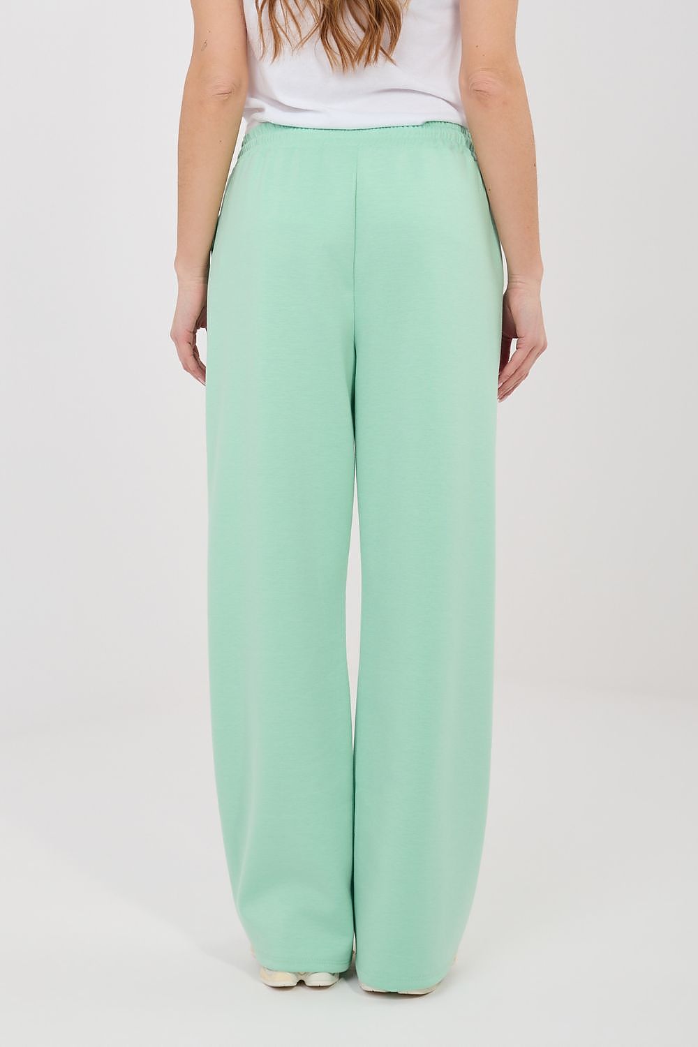 Mint green tracksuit trousers with elastic waist and relaxed wide-leg fit.