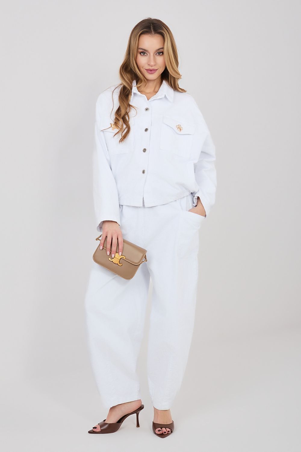 White corduroy trousers with buttoned front, belt loops, and side pockets