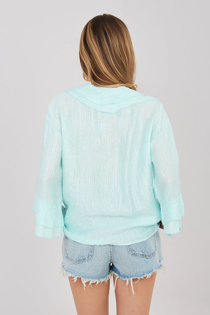 Light blue long-sleeve ruffle-back shirt with hooded collar and button placket