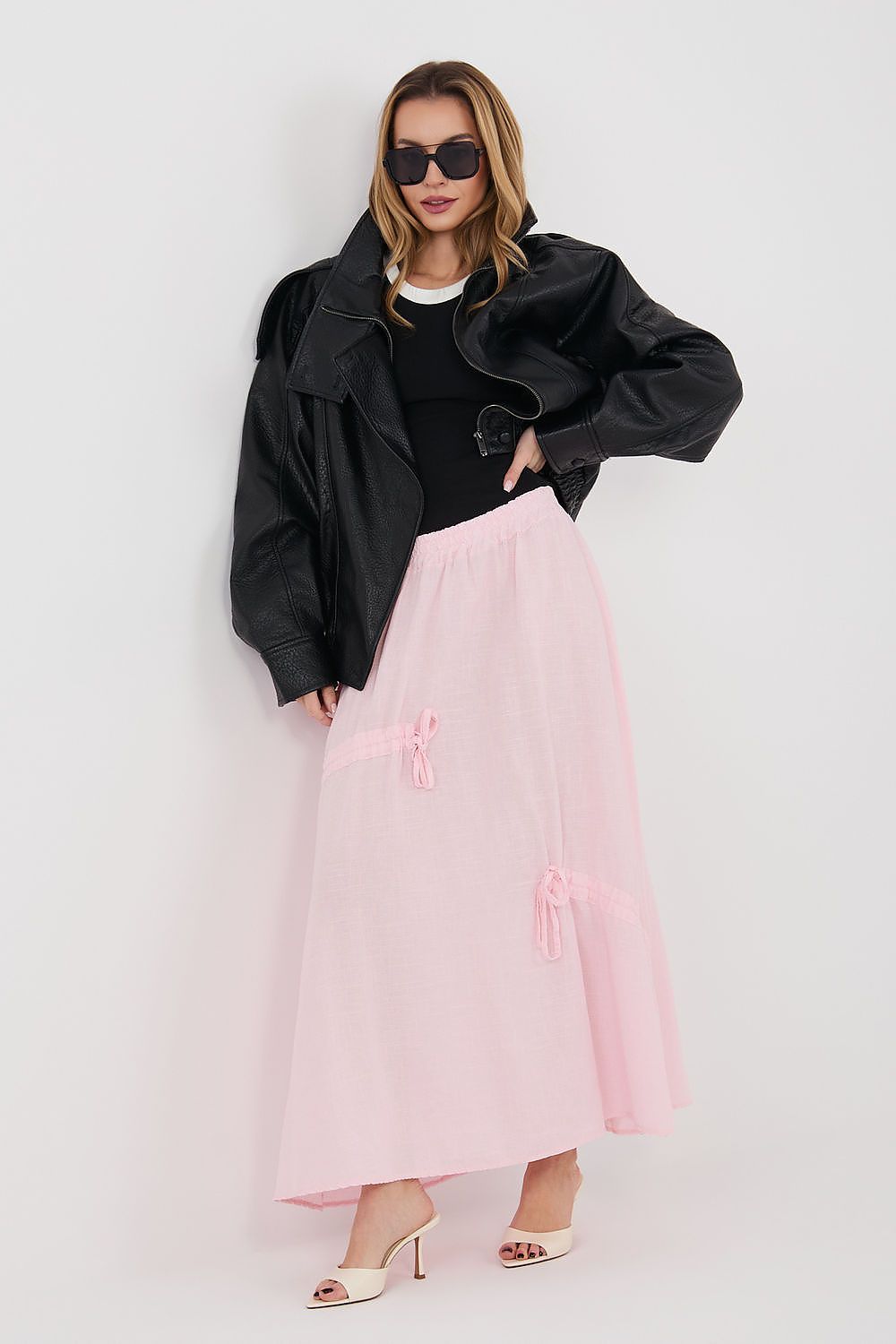 Pink long skirt with elastic waist and bow-tie details, flowing midi length
