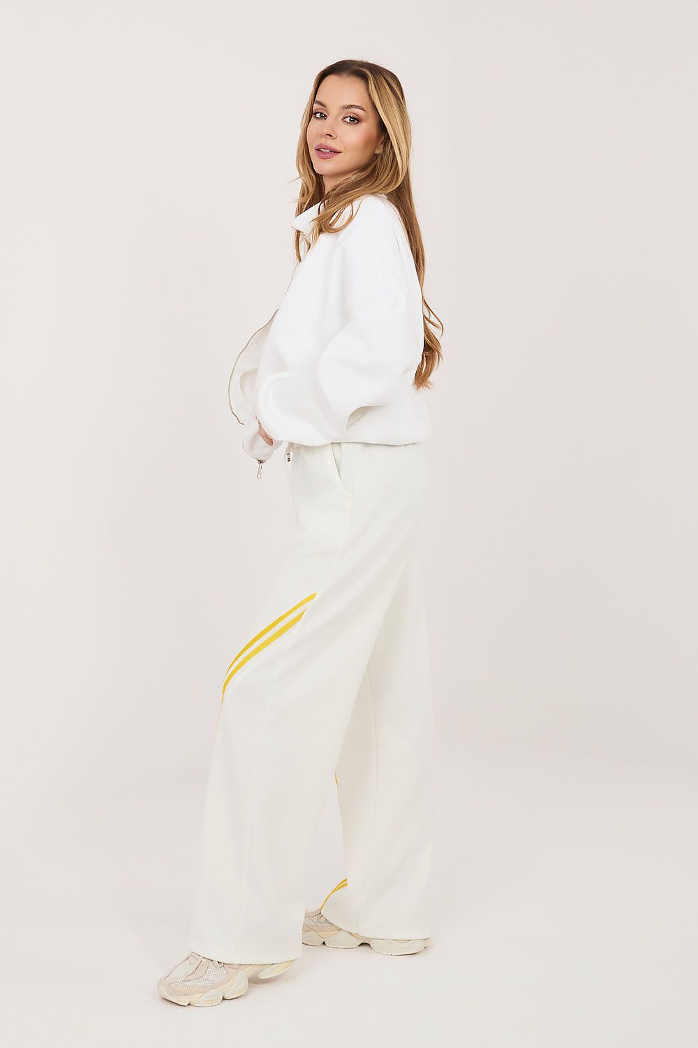 Beige track pants with yellow side stripe and relaxed straight-leg fit