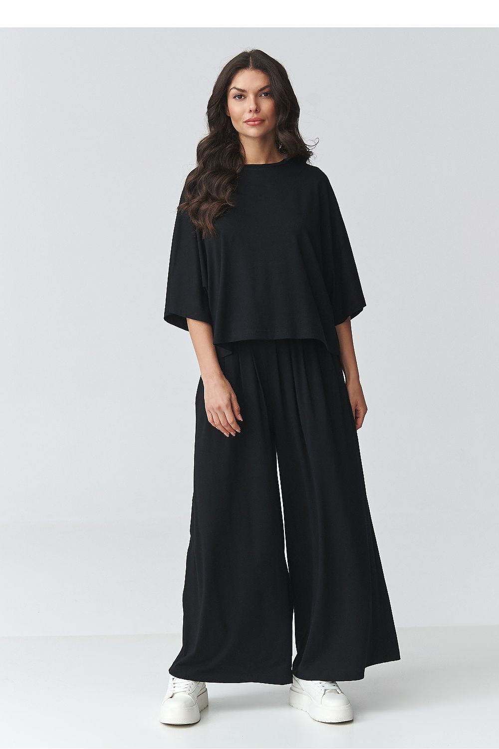 Black loose top and wide-leg pants set with draped sleeves and elastic waist