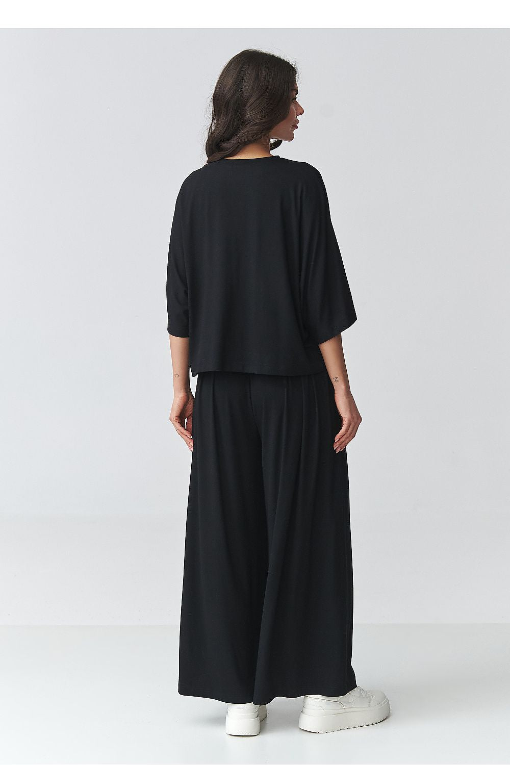 Black two-piece outfit set shown from back with dolman-style top and wide trousers