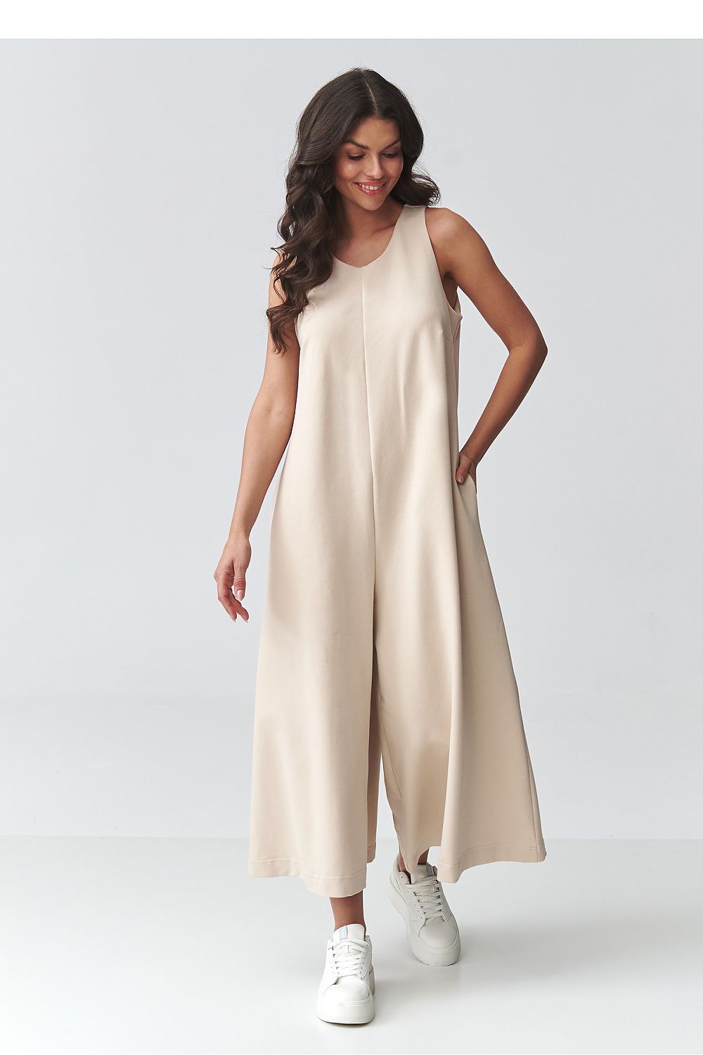 Beige sleeveless wide-leg jumpsuit with long drape and relaxed straight fit