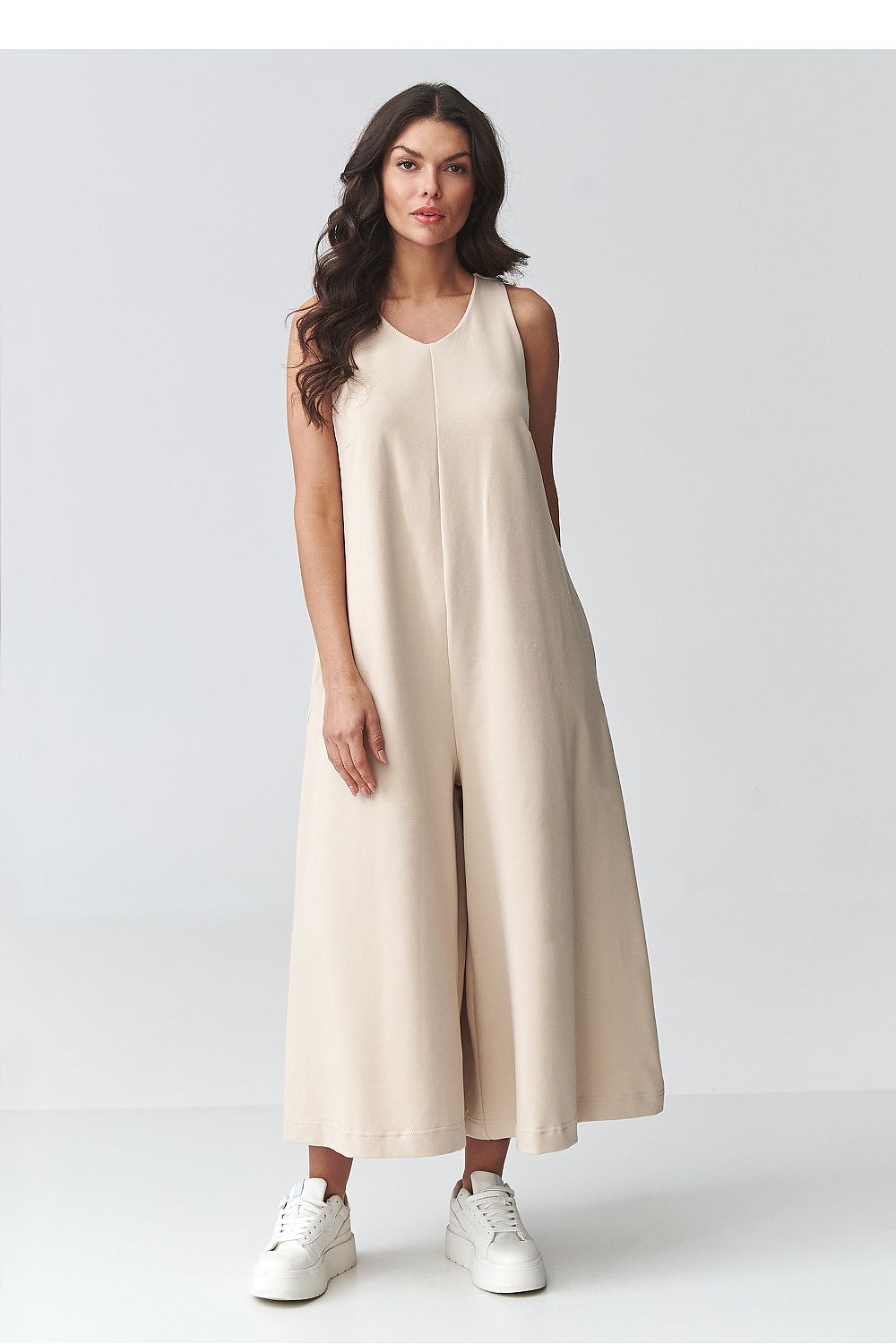Beige sleeveless wide-leg jumpsuit, side view, long relaxed silhouette