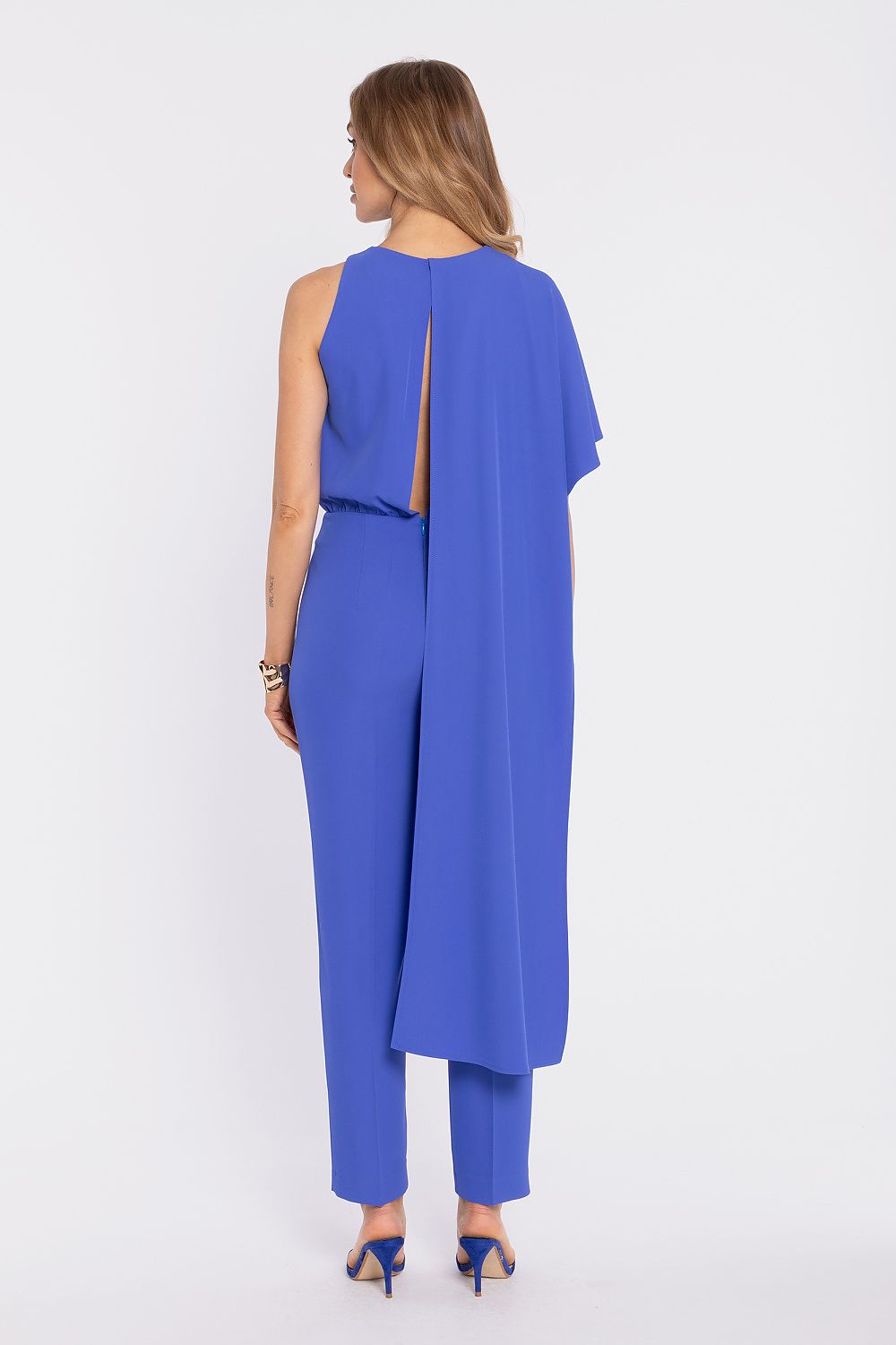 Blue sleeveless back view jumpsuit with long draped overlay and tapered pants