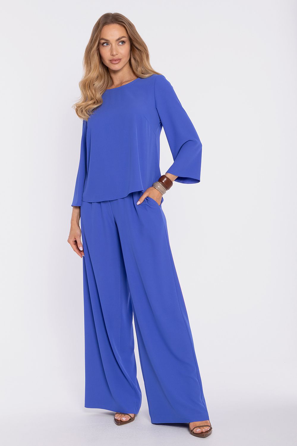 Blue blouse with long flared sleeves and round neck; matching wide-leg pants.