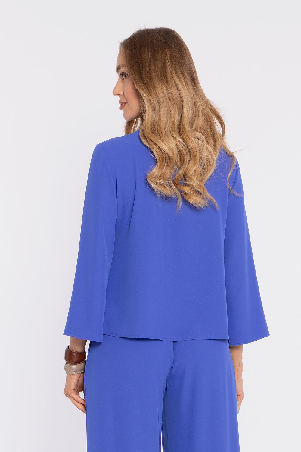 Blue blouse from side view with flared sleeves and round neckline; matching pants.