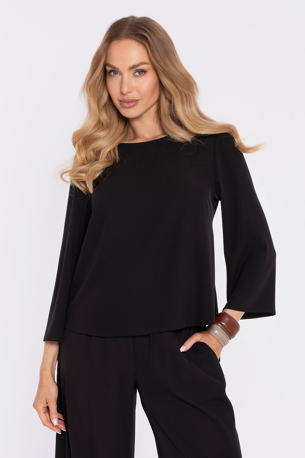 Black blouse with round neckline and long flared sleeves; matching pants.