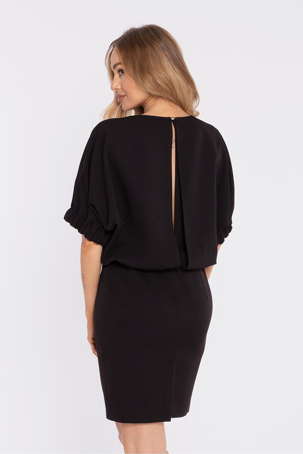 Black daydress back view with puff sleeves and waistband seam, knee-length skirt