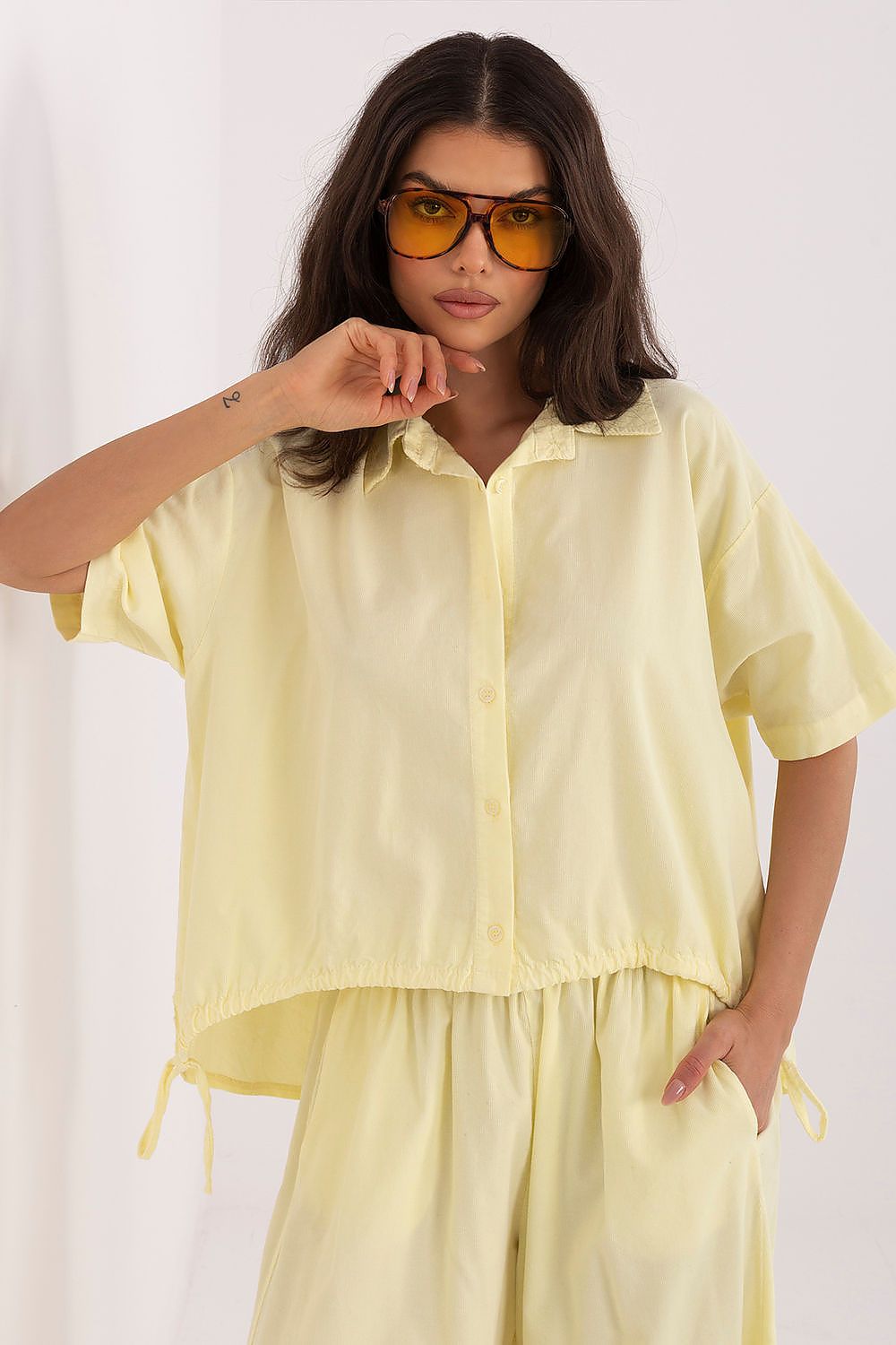 Short-sleeve button-up shirt in pale yellow with collar and drawstring hem ties