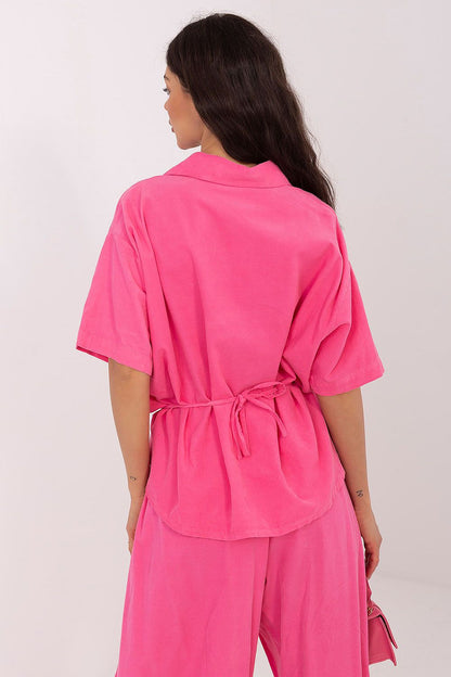 Short-sleeve button-up shirt in bright pink, back view with waist tie detail
