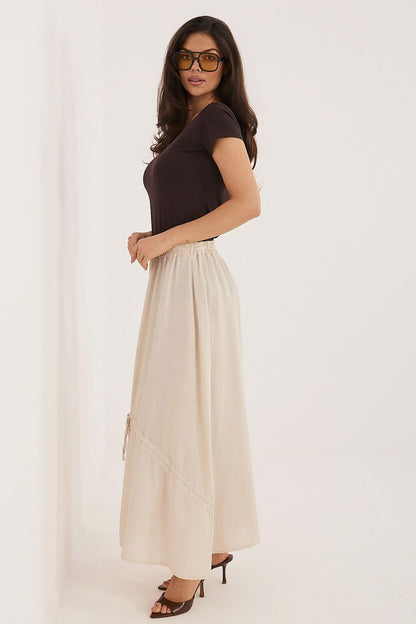 Cream long skirt with gathered waist and tassel drawstring side ties, front view