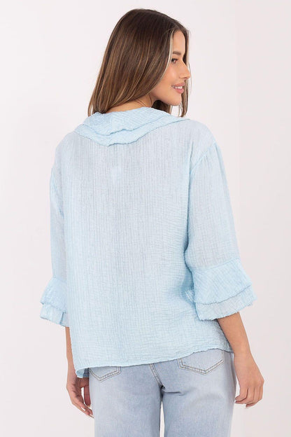 Light blue long-sleeve shirt, back view with buttoned yoke and flared cuffs