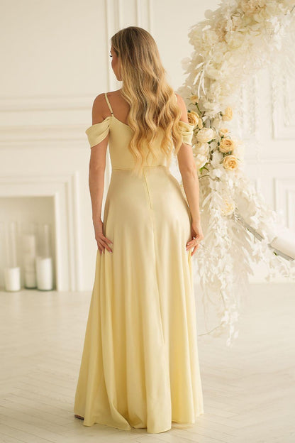 Back view of long off-shoulder maxi dress in light yellow with gathered, flowing skirt