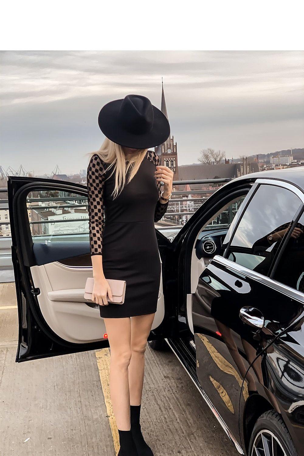 Black fitted mini dress with sheer polka-dot sleeves, back view