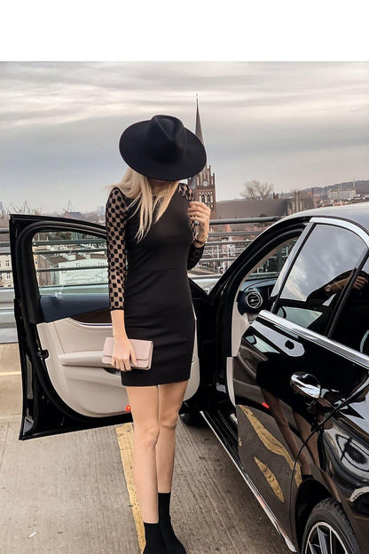 Black fitted mini dress with sheer polka-dot sleeves, back view