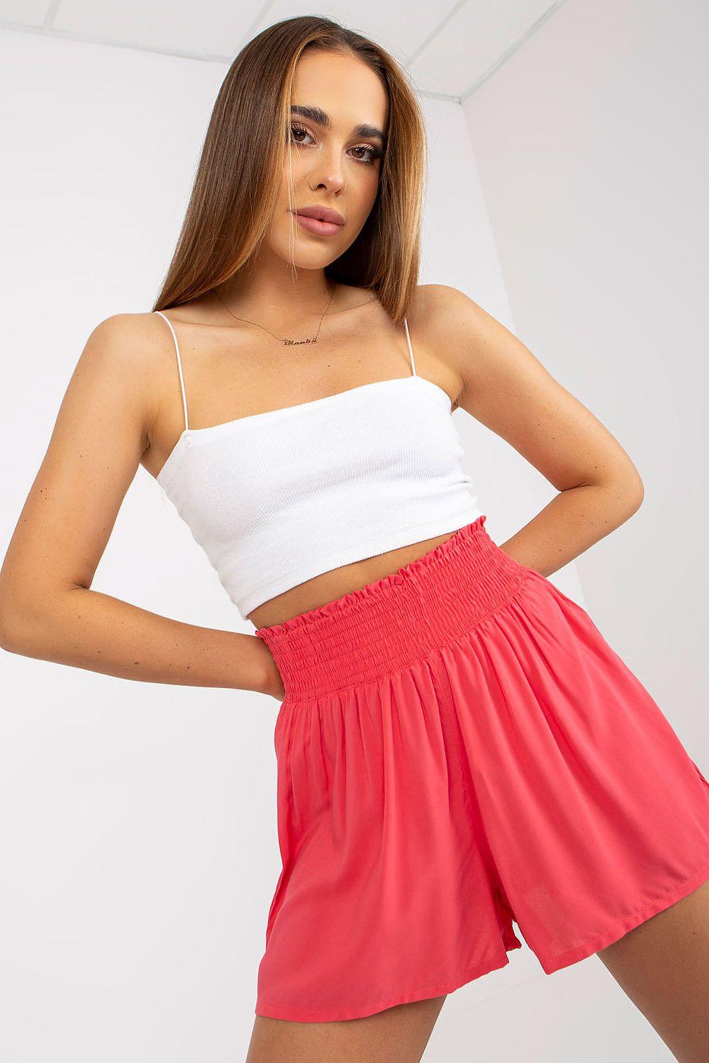 Pink elastic-waist shorts with gathered skirt, above-knee length.