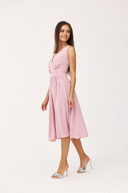 Pink V-neck sleeveless midi cocktail dress with wrap-style bodice and pleated skirt, side pose