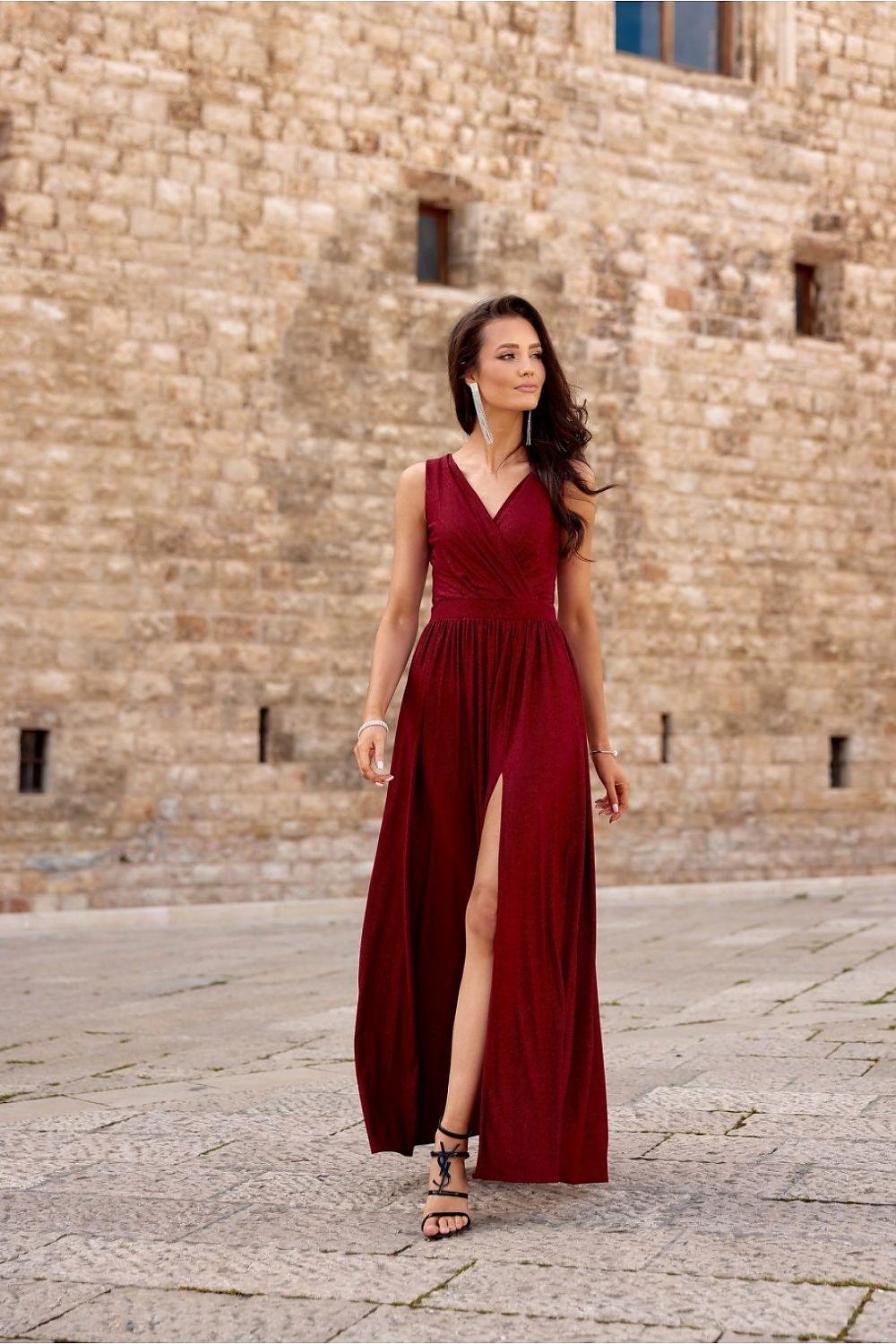 Red long sleeveless dress with V-neck, gathered waist, and side thigh slit.