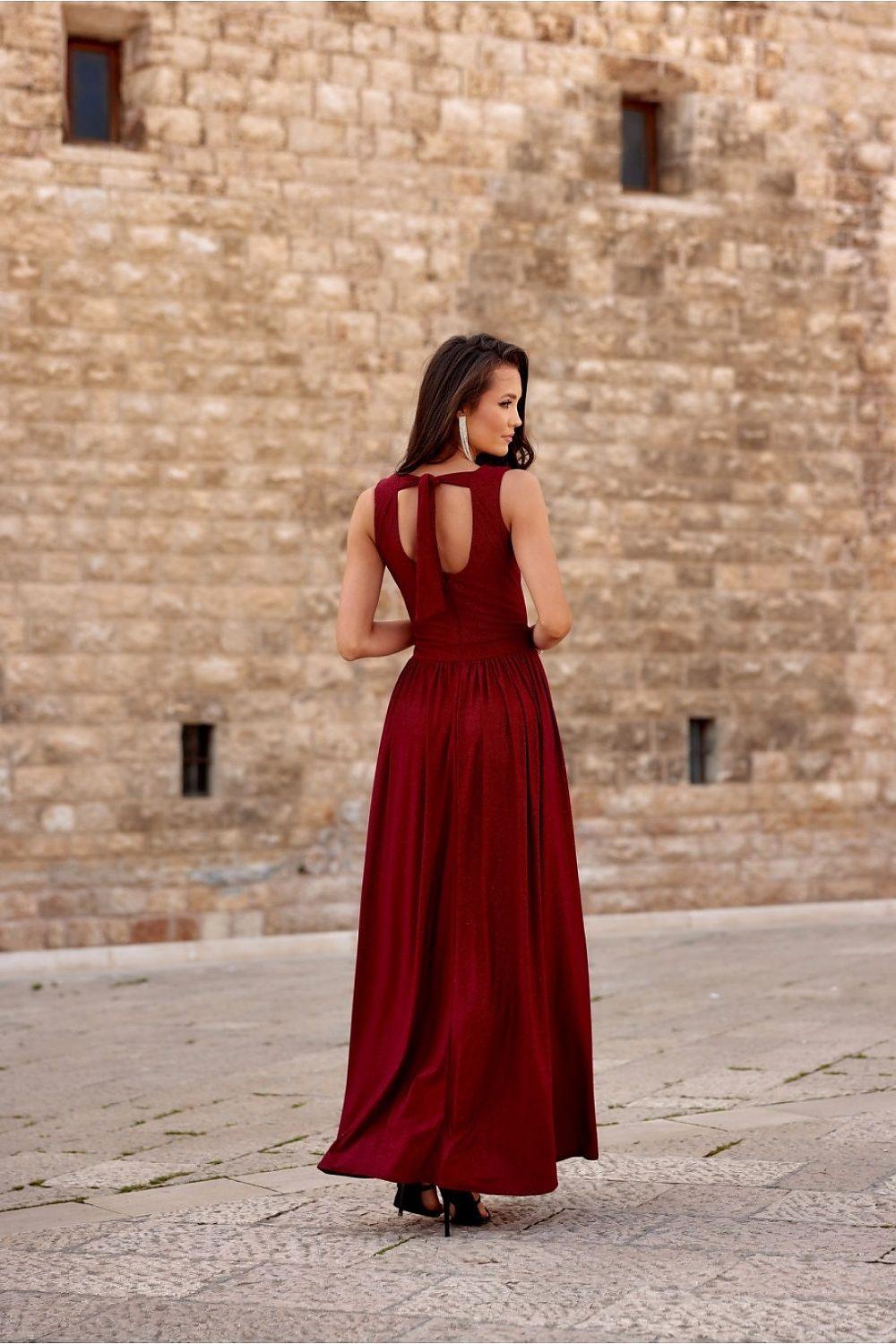 Red long sleeveless dress with open-back cutouts and flowing skirt with slit.