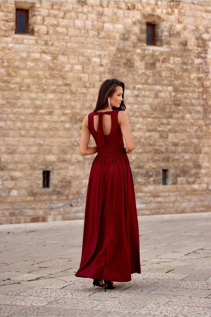 Red long sleeveless dress with open-back cutouts and flowing skirt with slit.